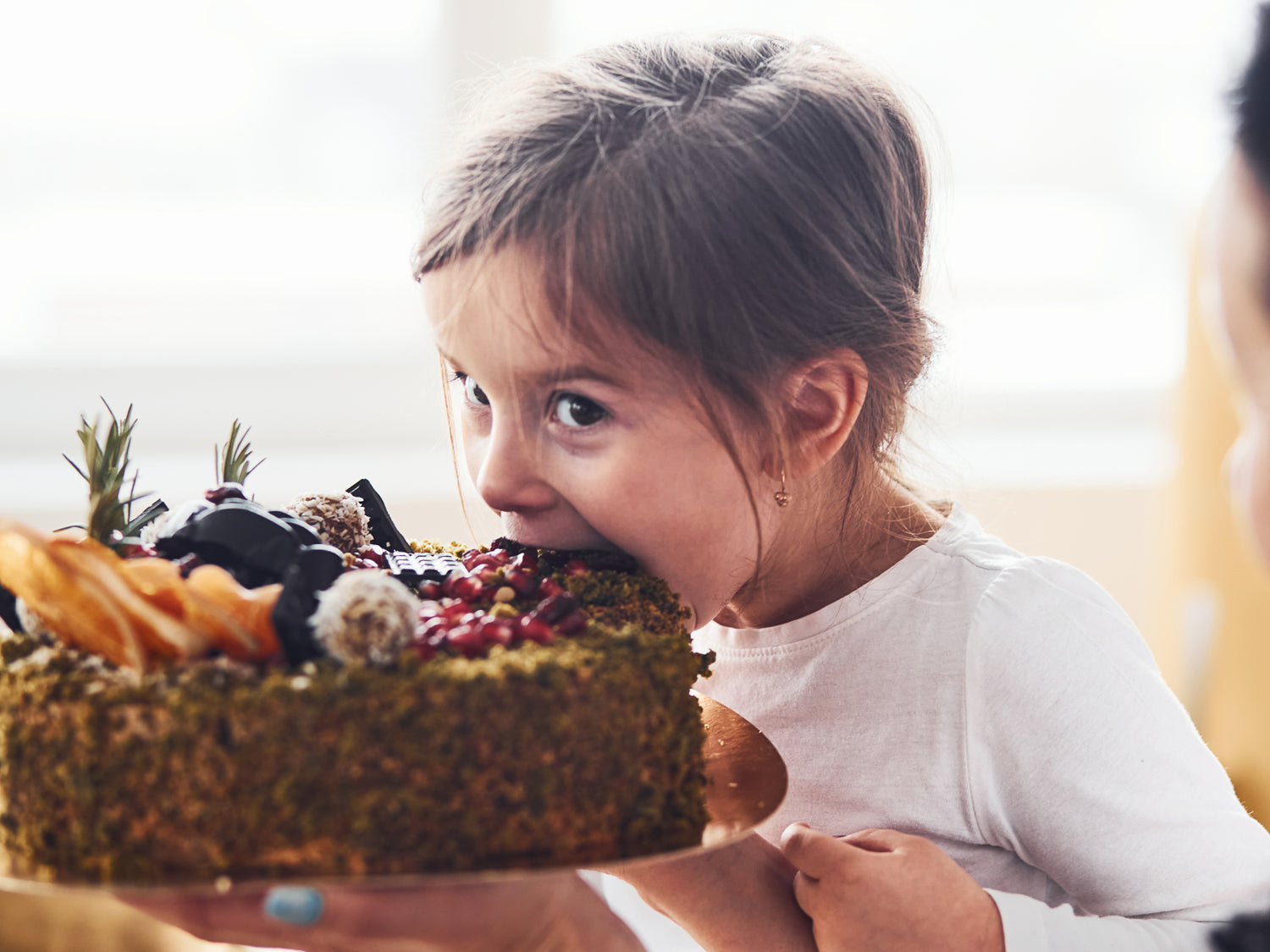Mädchen beißt in glutenfreien Kuchen